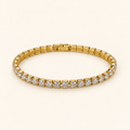 Gold-tone bracelet on an ivory background