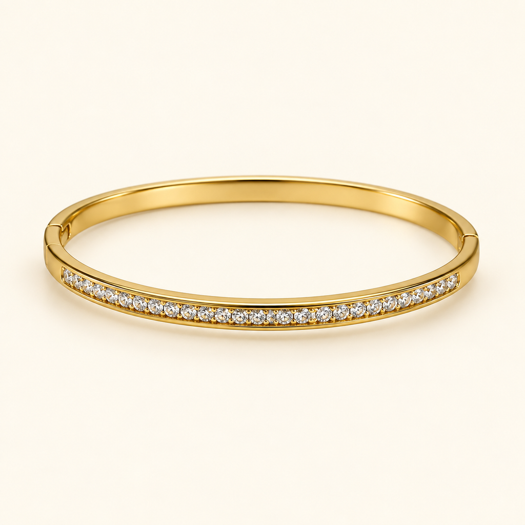Gold-tone bangle on an ivory background